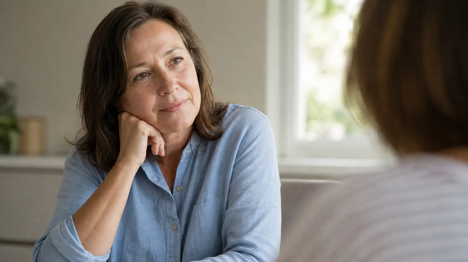 An adult listens with their chin resting lightly against one hand · Addiction Treatment for Atlantis, FL Residents