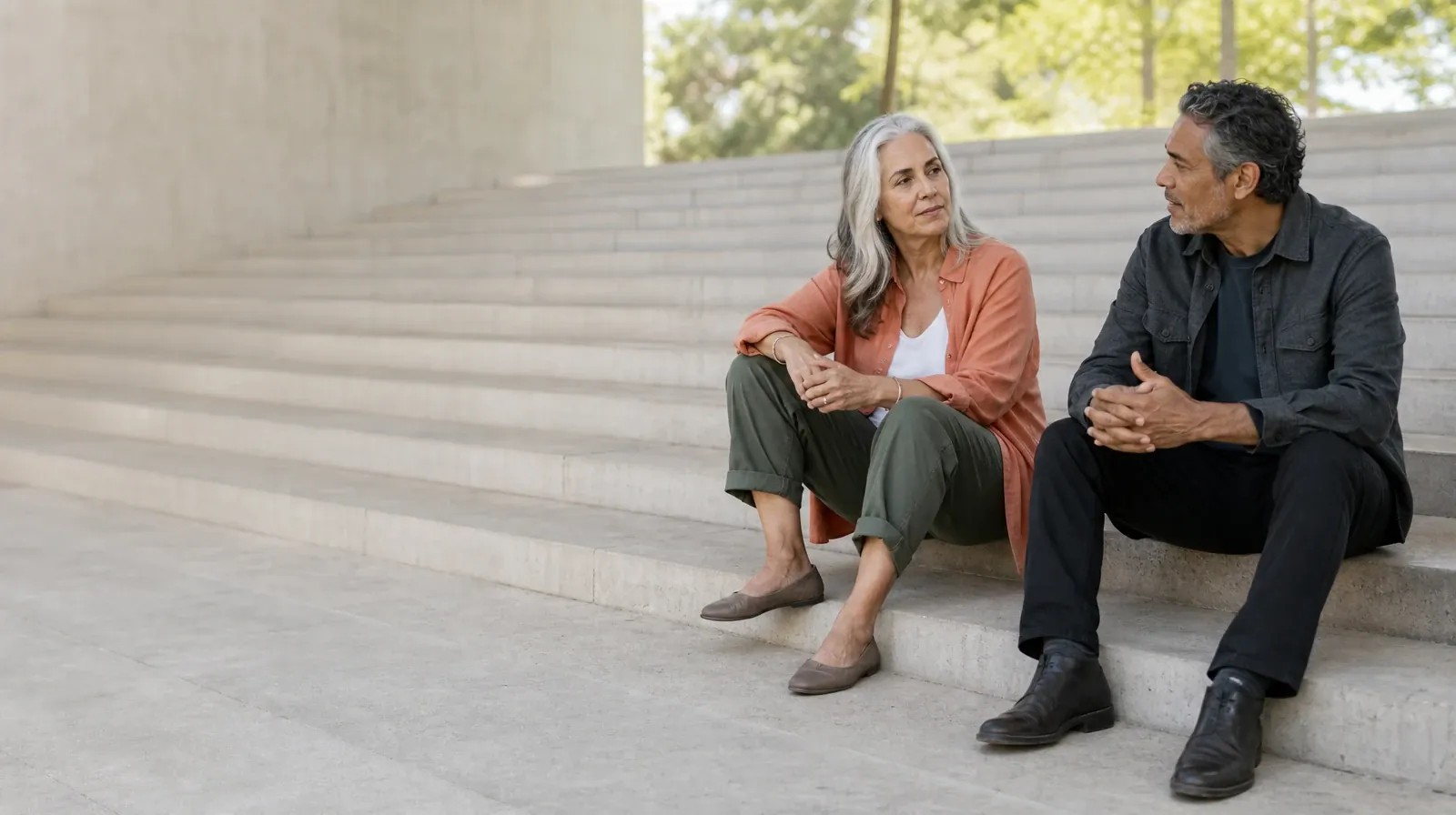Two adults talk while seated on broad outdoor steps · Planning a Treatment Assessment for Cooper City, FL Residents