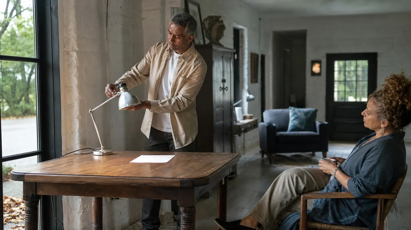 An adult adjusts a desk lamp beside blank paper · Returning Home After Treatment for Kendall West, FL Residents