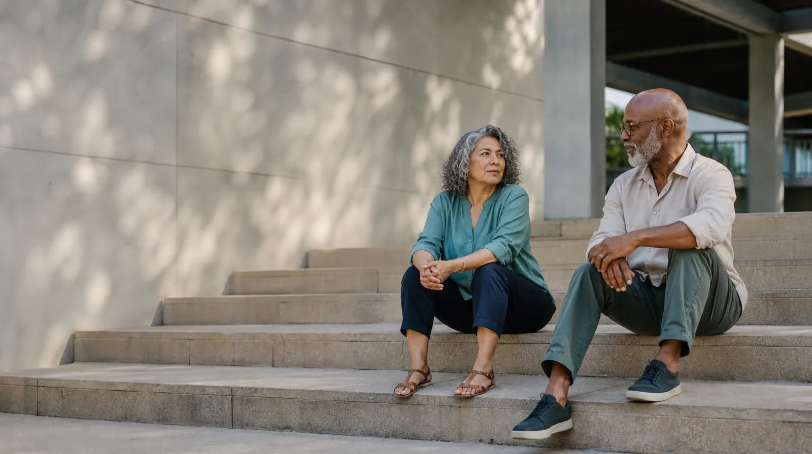 Two adults talk while seated on broad outdoor steps · Addiction Treatment for Coral Way, Miami, FL Residents