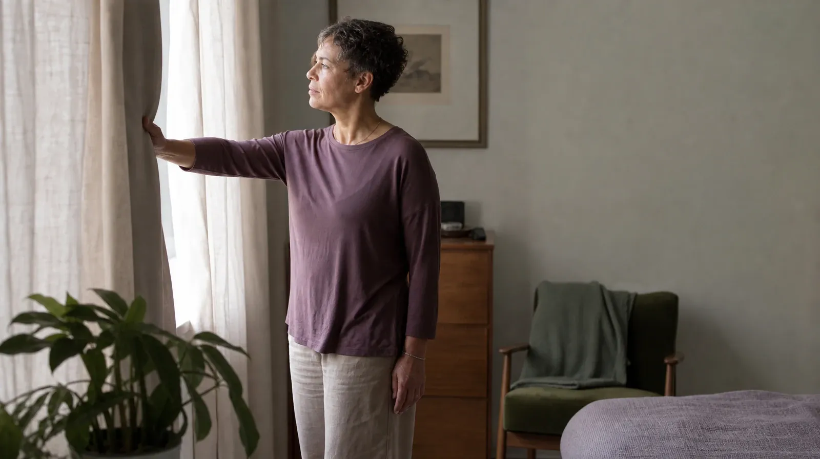 An adult opens a plain curtain in morning light · Residential Addiction Treatment for Downtown, Miami, FL