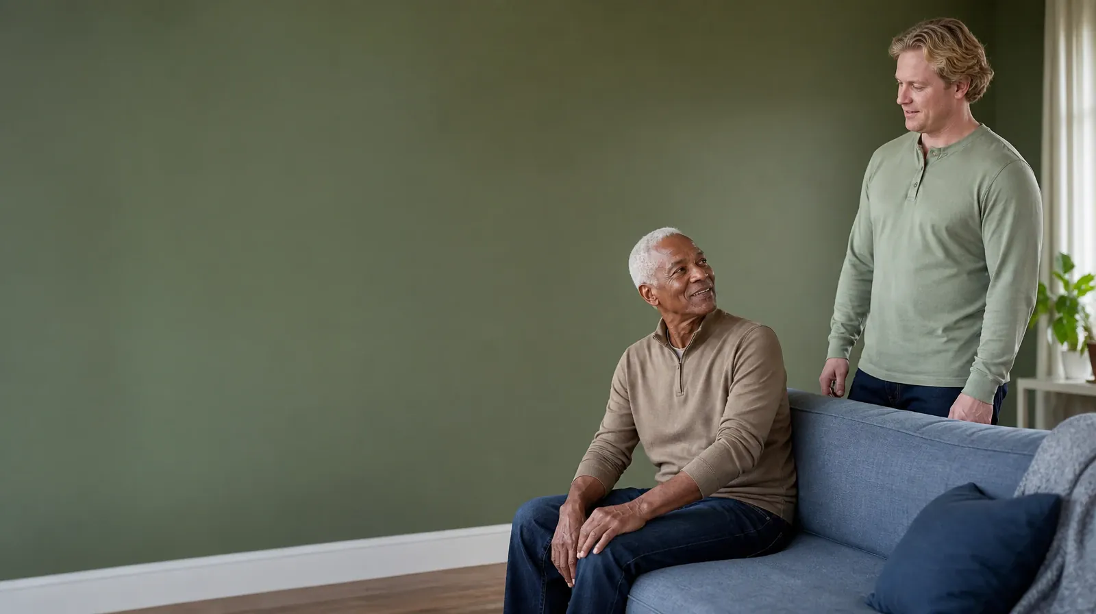 An adult seated sideways on a low sofa looks up toward another adult… · Addiction Treatment for Miami Shores, FL Residents