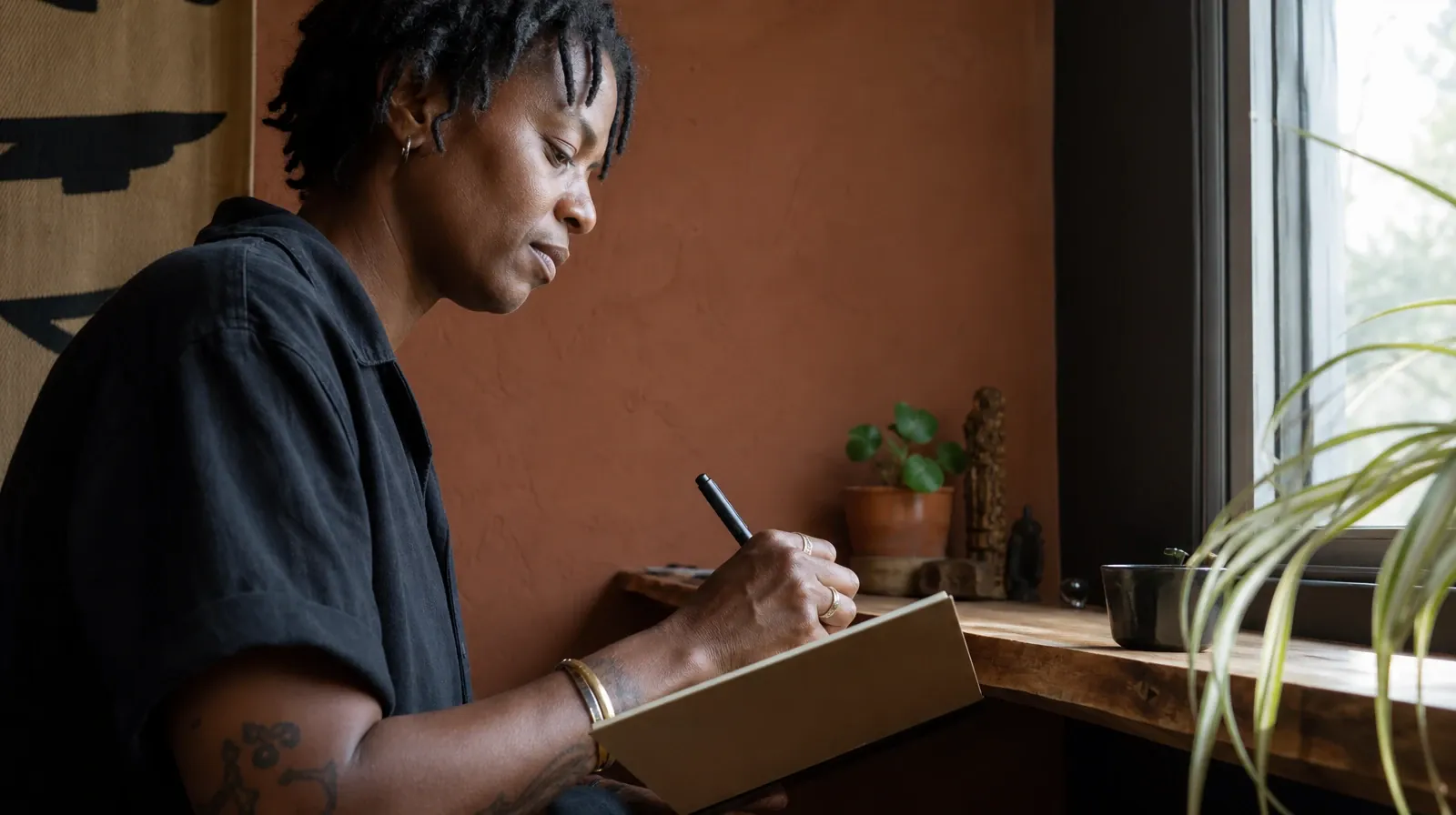An adult writes in a notebook at a home shelf, with the page… · Alcohol Addiction Treatment for Wynwood, Miami, FL Residents