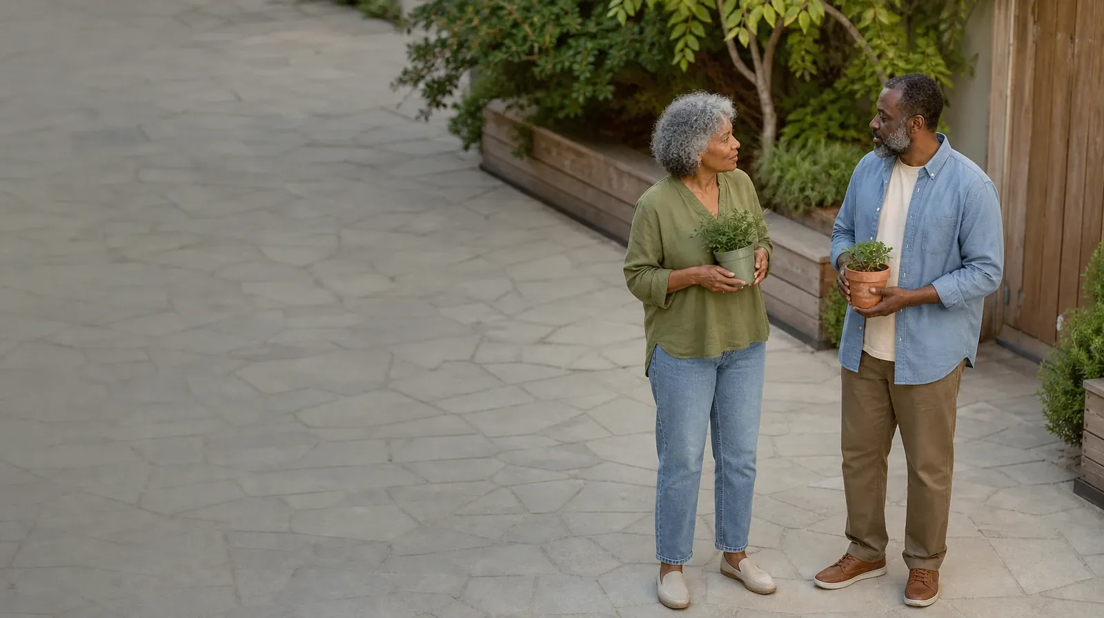 Returning Home After Treatment for Plantation, FL Residents | Two adults pause with small plants in a courtyard Two adults pause with small plants in a courtyard · Returning Home After Treatment for Plantation, FL Residents