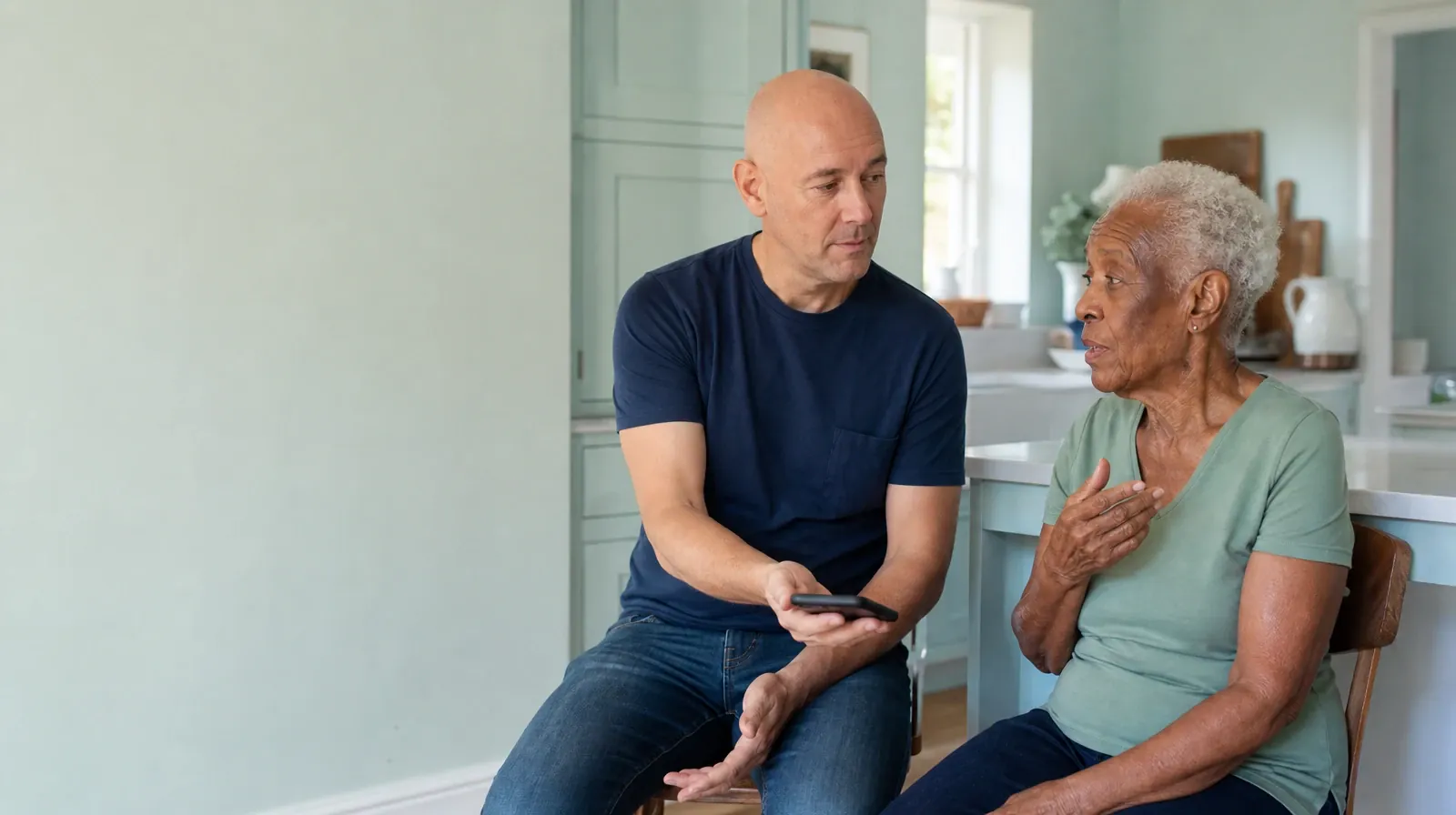 Two adults share a phone conversation, with one holding… · Returning Home After Treatment for Plantation Key, FL Residents