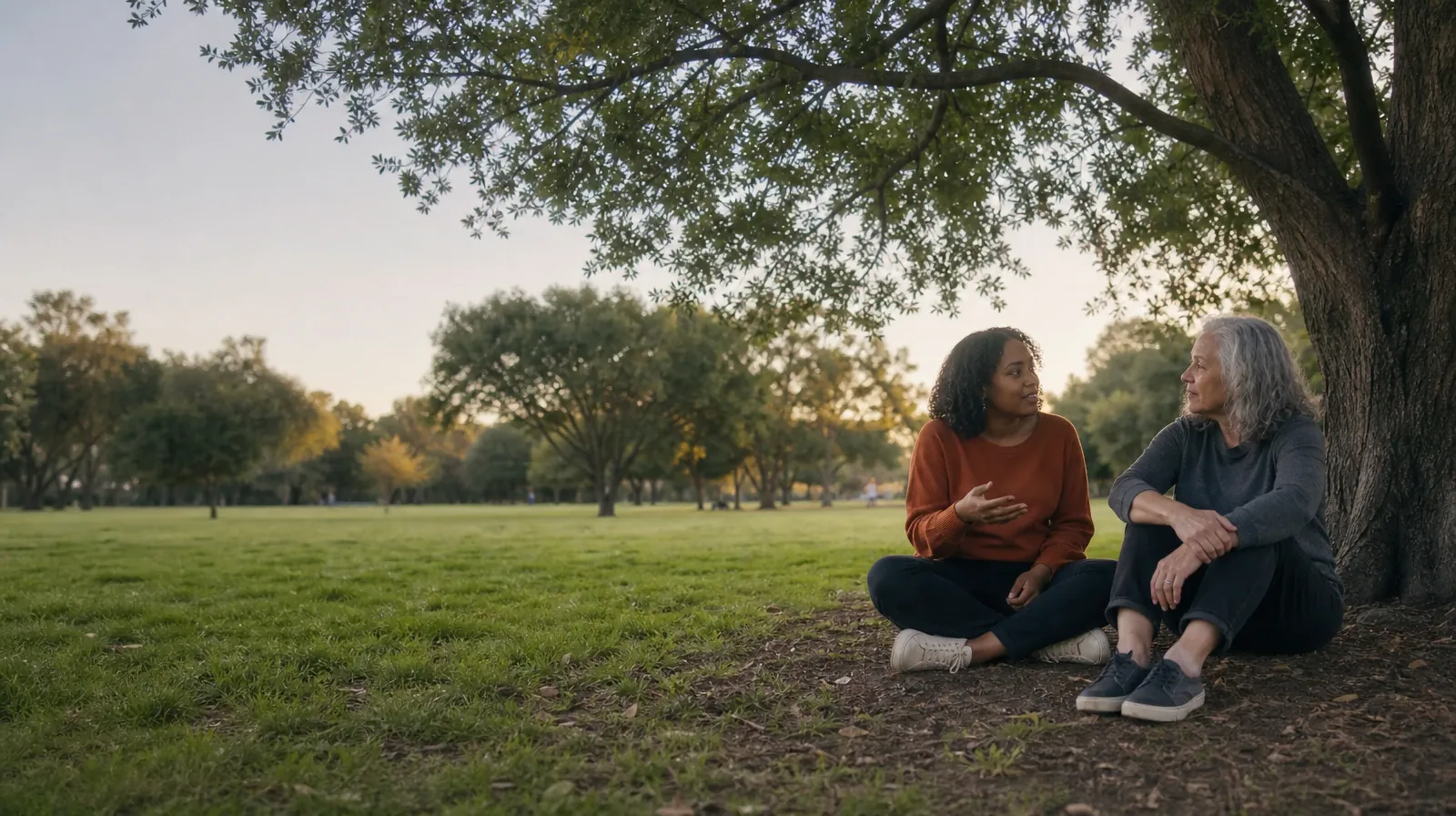 Two adults talk beneath a tree at a public green · Supporting an Adult Loved One for Shark Key, FL Residents