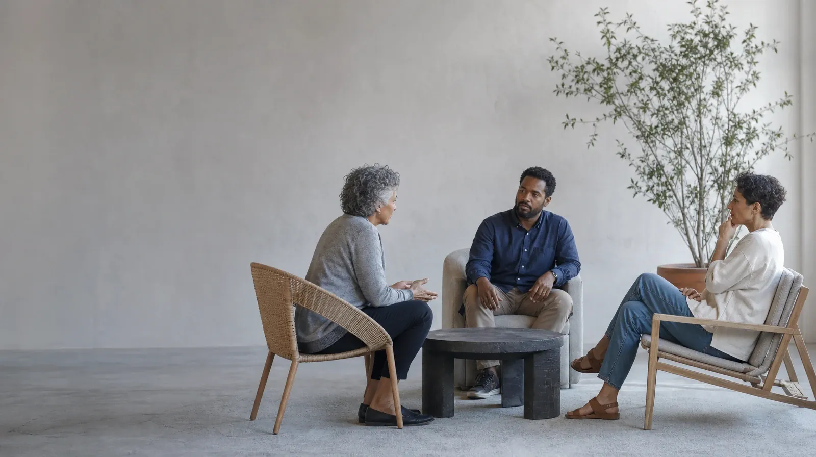 Supporting an Adult Family Member With Barbiturates Use | Three adults talk in mismatched chairs around an empty table Three adults talk in mismatched chairs around an empty table · Supporting an Adult Family Member With Barbiturates Use