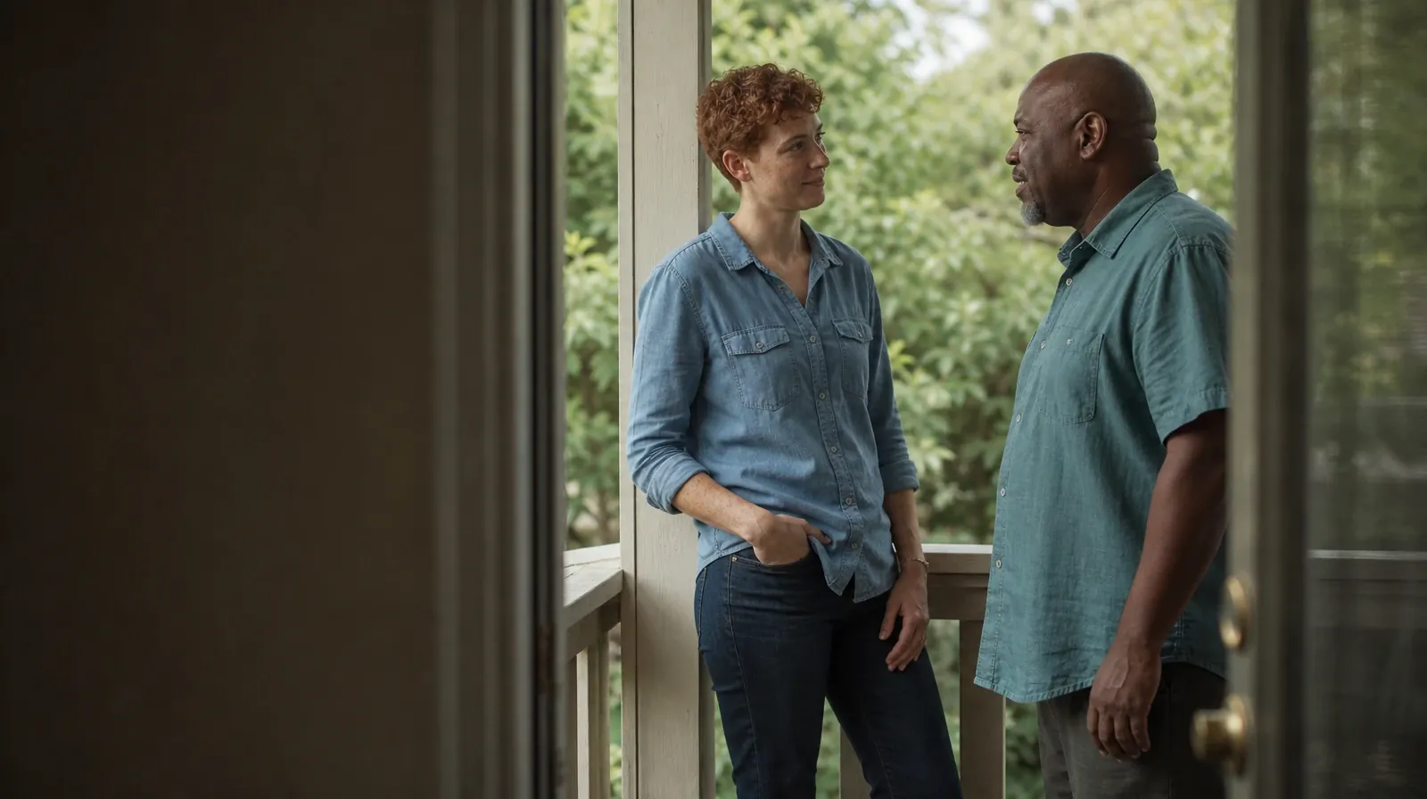 Two adults talk on a porch, viewed past the edge of an open screen door · GHB Addiction Treatment in Miramar, FL
