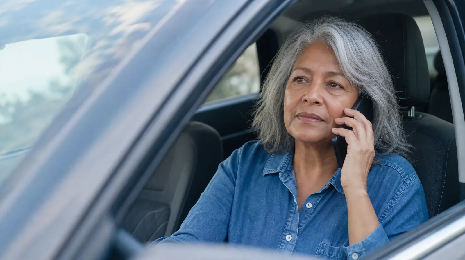 An adult listens on a phone while seated in the passenger seat of a parked car · Ketamine Addiction Treatment in Miramar, FL