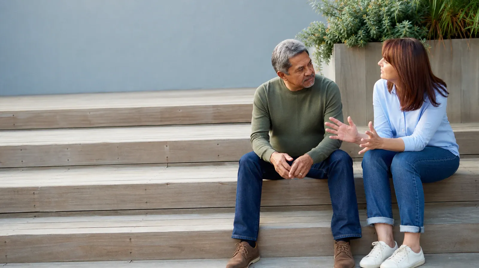 Two adults talk while seated on broad steps · Nitrous Oxide Pain and Treatment Questions