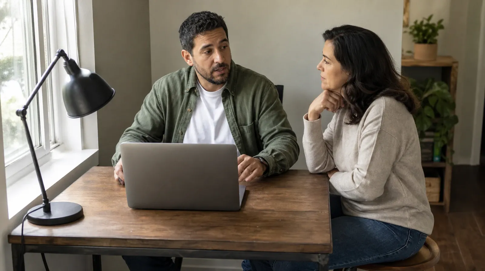 An adult speaks with a friend beside an open laptop at a small home… · Prescription drugs Addiction Treatment in Miramar, FL