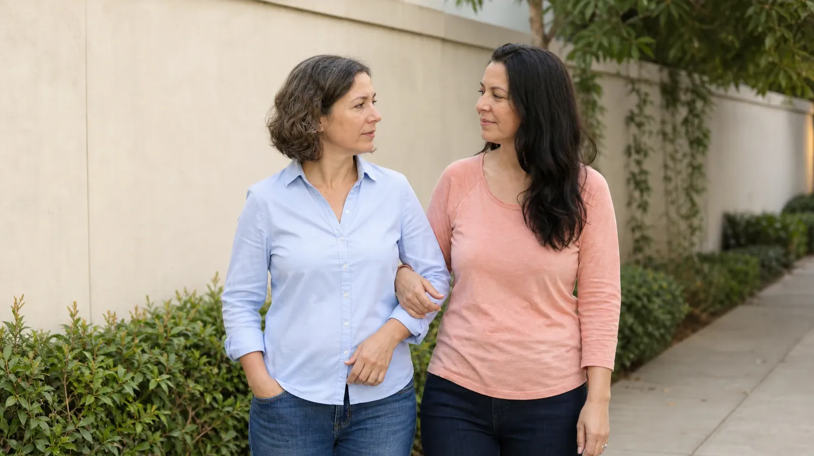 Two adults pause side by side on a level path with their arms loosely linked at… · Valium Addiction Treatment in Miramar, FL