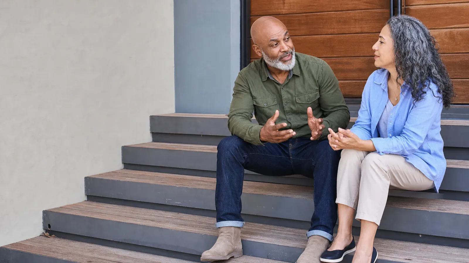 Two adults talk while seated on broad steps · ACT After Residential Care
