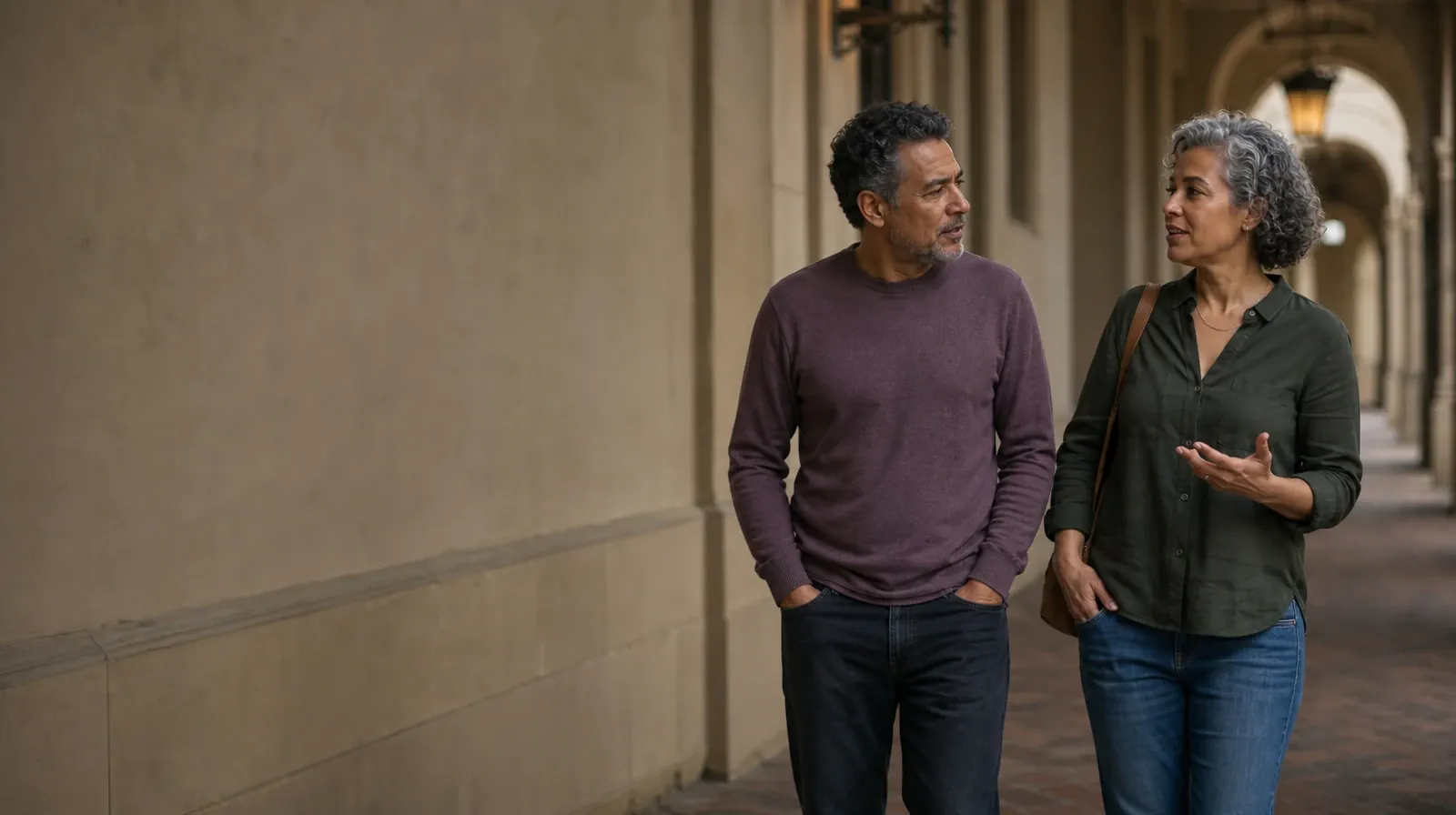 Two adults walk and talk beneath a covered arcade · Previous Behavioral Couples Therapy Experience