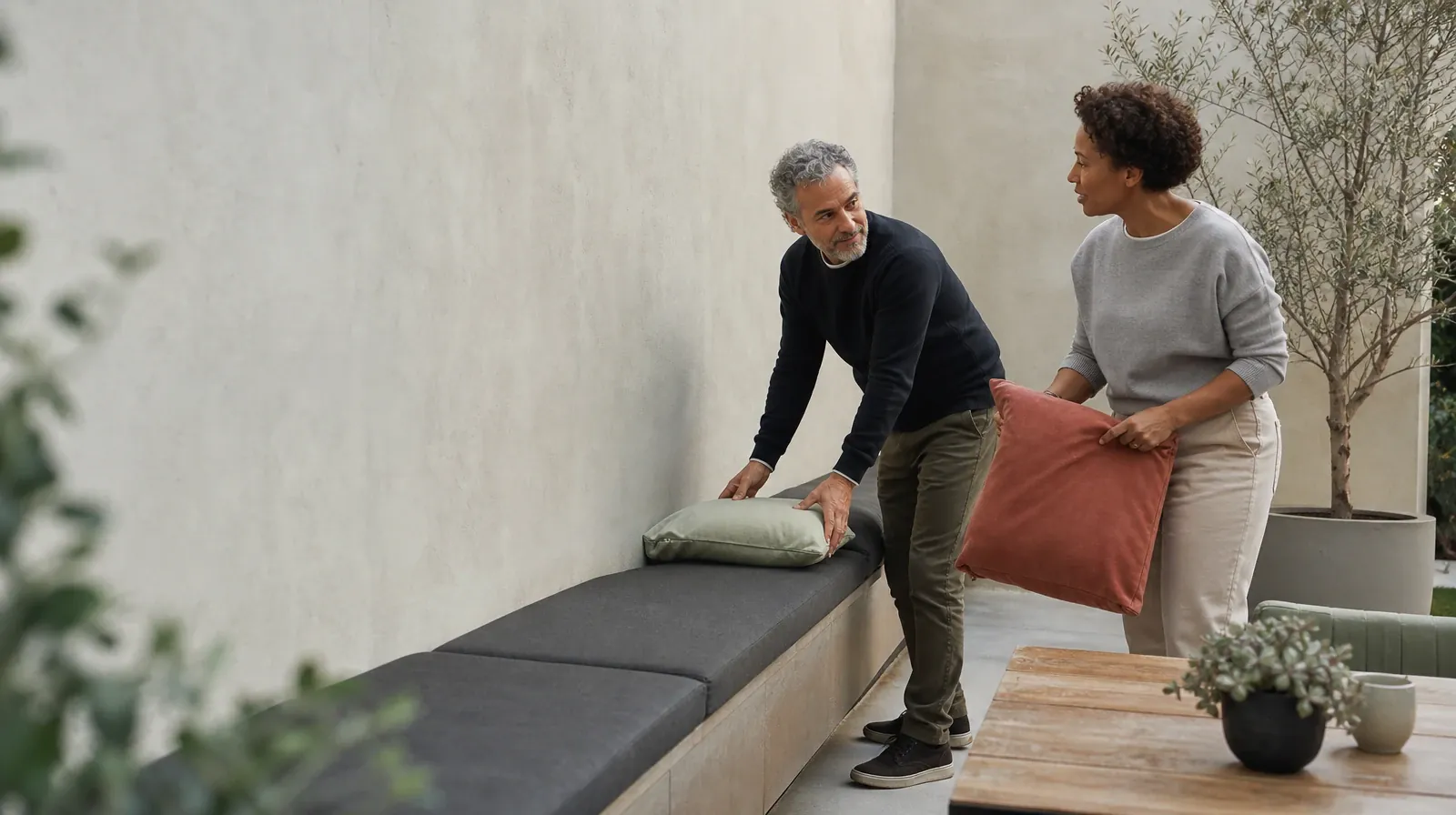Two adults pause while arranging cushions on a bench · Qualified Behavioral Couples Therapy Questions