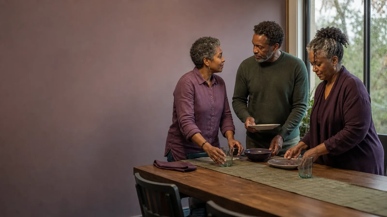 Reviewing Progress in Behavioral Couples Therapy | Three adults pause while setting a plain table Three adults pause while setting a plain table · Reviewing Progress in Behavioral Couples Therapy