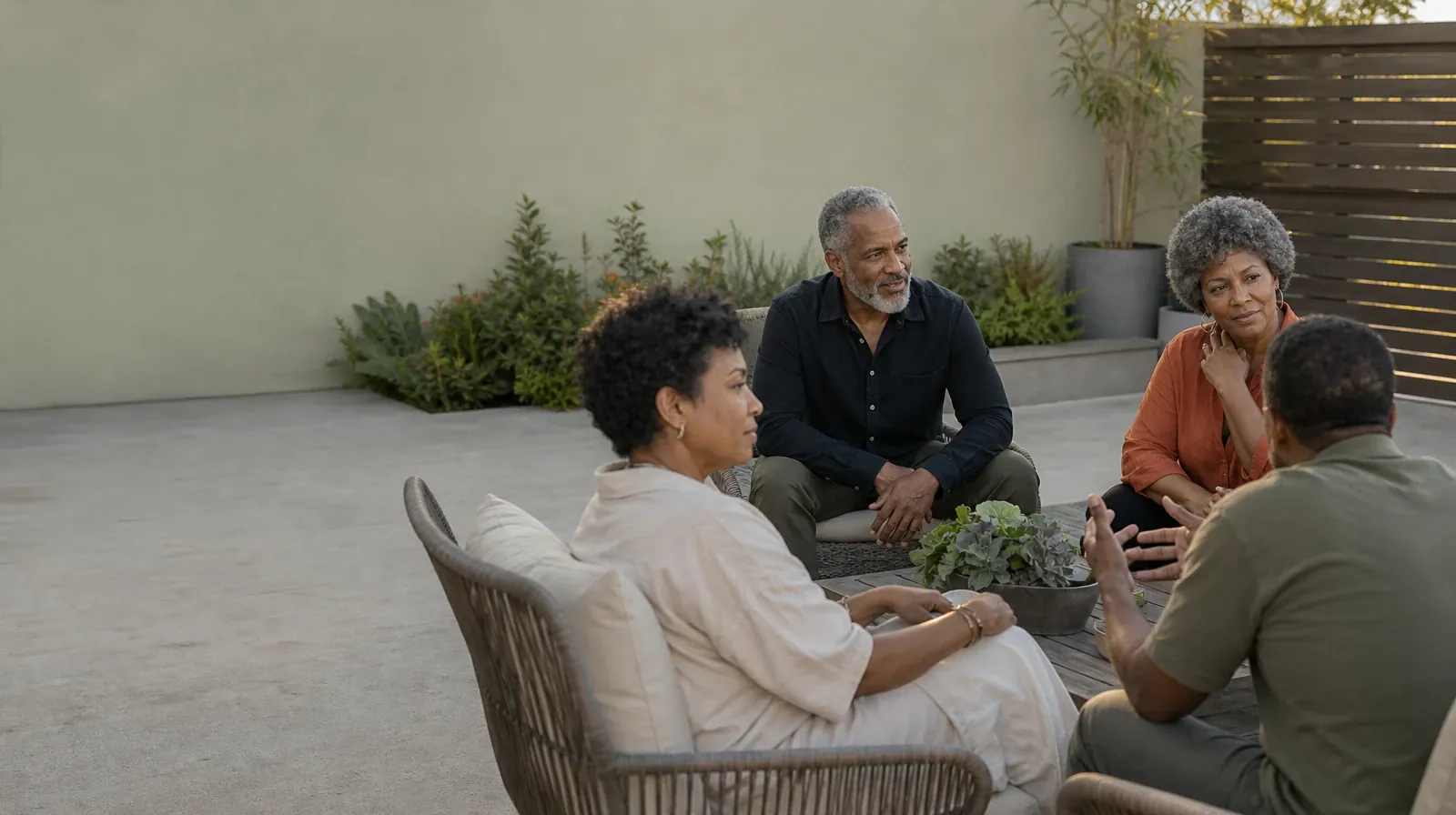 Four adults share a casual patio conversation · Emotion Regulation: Practitioner Questions