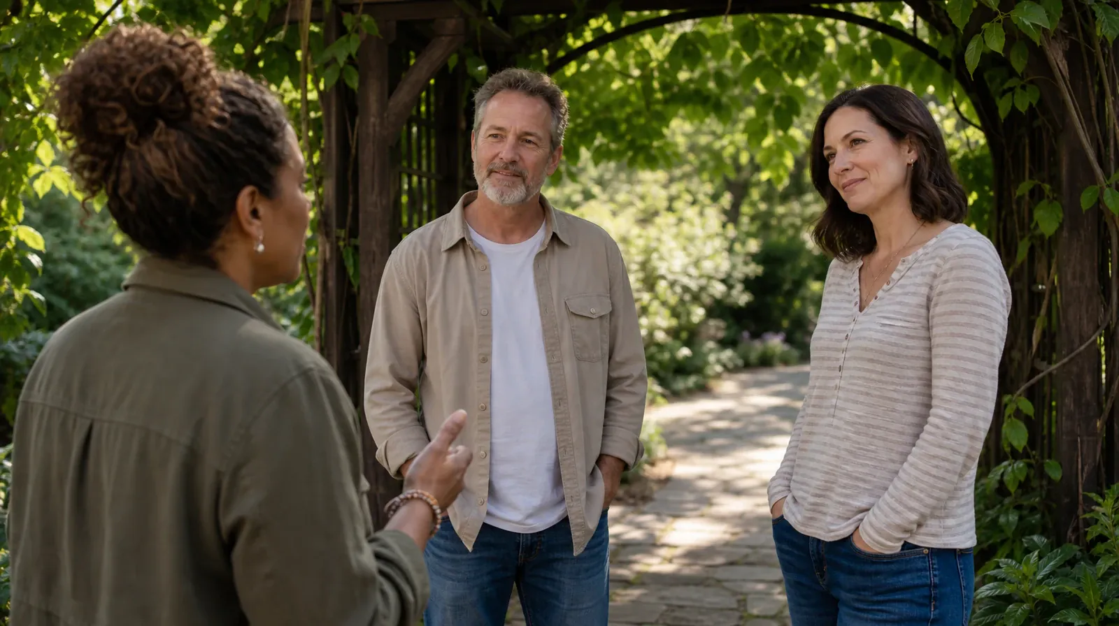 Three adults pause beneath a garden arbor, with two… · Experiential approaches for Addiction Treatment in Miramar, FL