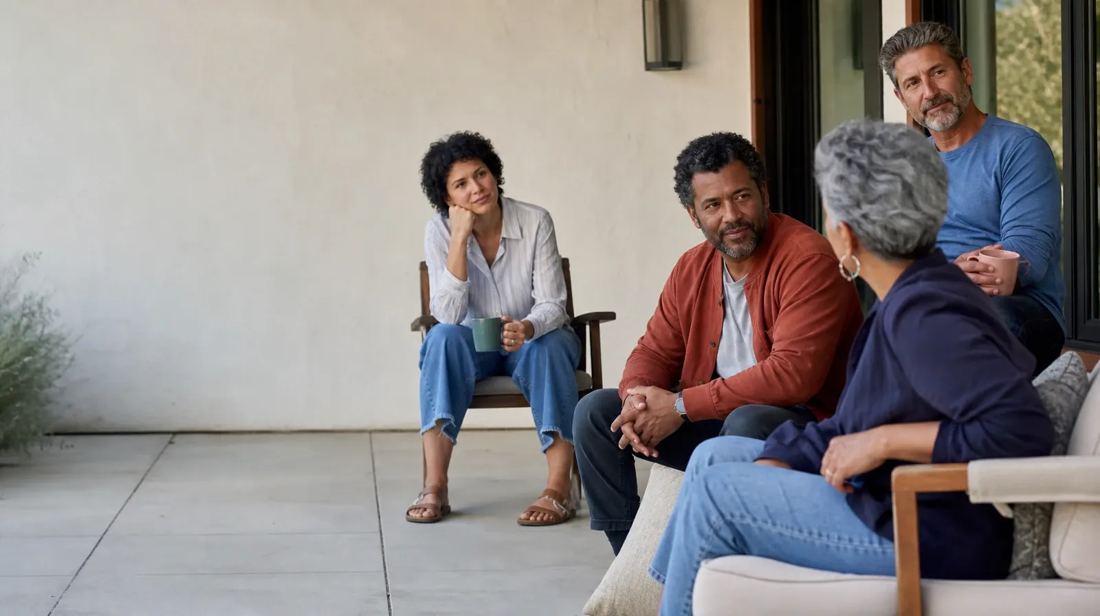 Four adults share a casual patio conversation · After Residential Care and Group therapy in South Florida