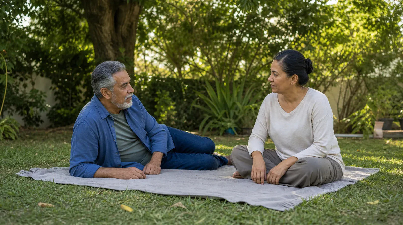 Two adults face each other on a plain blanket on grass, one… · Stress management for Addiction Treatment in Miramar, FL