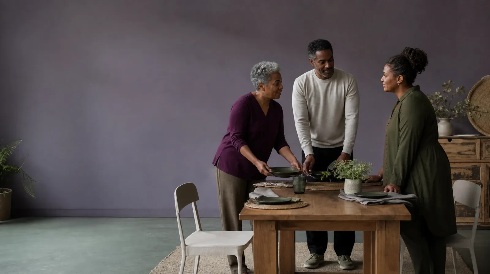 Three adults pause while setting a plain table · Privacy and Consent in Trauma-informed care in South Florida